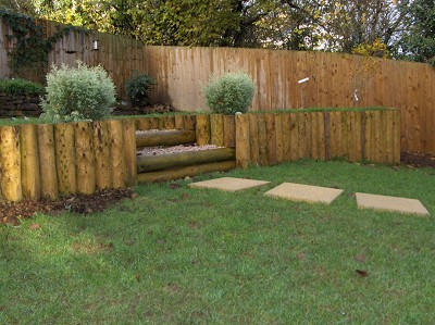 Raised lawn area edged with rustic logs.
