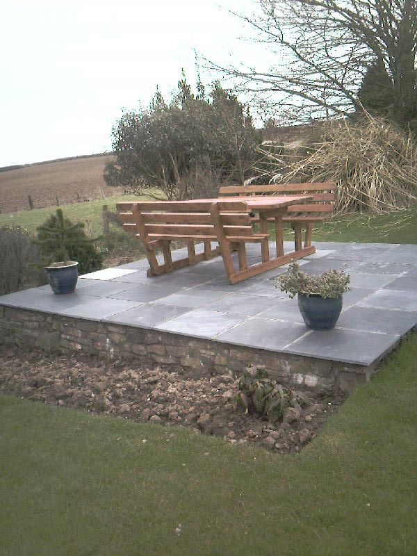 Slate patio with stone retaining walls.